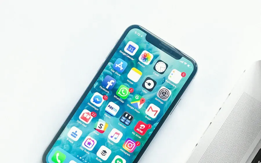Smartphone showing apps beside a laptop